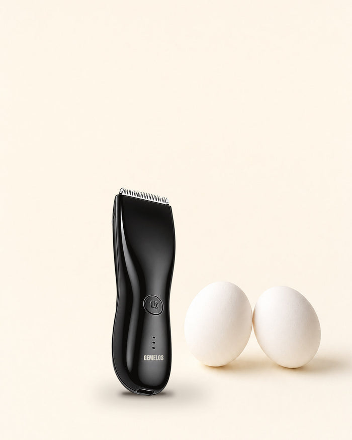 Recortadora íntima negra junto a dos huevos sobre fondo crema, con el logo GEMELOS en el cuerpo